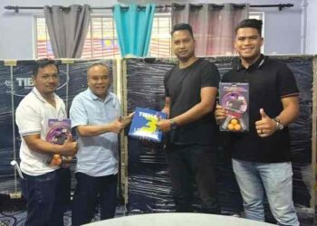 MUSTAPA Long menyampaikan bantuan peralatan permainan ping pong kepada seorang wakil persatuan belia di Dataran Tok Linggi, Kampung Relong, Lipis baru-baru ini. – UTUSAN/HARIS FADILAH AHMAD