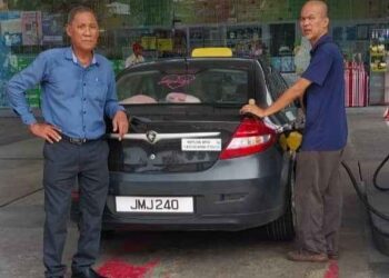 MUSTAKIM Jalel (kiri) bersama seorang ahli persatuan ketika mengisi minyak petrol di Kluang.