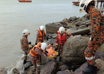 ANGGOTA bomba mengangkat mayat yang ditemukan terapung di kawasan berbatu di Port Dickson Waterfront tengah hari tadi.-GAMBAR/IHSAN BOMBA
