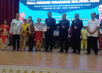 TIMBALAN Pengerusi Jawatankuasa Pendidikan, Pengajian Tinggi dan Hal Ehwal Agama Melaka, Rosli Abdullah (lima dari kanan) bersama Ronald Gan (dua dari kiri) menyampaikan hadiah kepada SJKC Bachang yang muncul juara pertandingan dondang sayang pada Festival Megah Bahasa di SJKC Pay Fong 1, Krubong, Melaka. - UTUSAN/AMRAN MULUP
