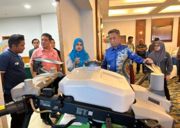 JALALUDDIN Alias (kanan) diberikan penerangan mengenai dron untuk aktiviti pertanian selepas meramikan pada Seminar Teknologi Padi dan Seminar Pemasaran Digital Industri Asas Tani Jabatan Pertanian Negeri Sembilan Tahun 2023 hari ini.