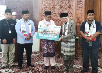 AMINUDDIN Harun (tengah) dan Ahmad Fahmi Mohd. Samsudin (kiri) ketika menerima sumbangan daripada pihak Majlis Agama Islam Negeri Sembilan (MAINS) untuk rakyat Palestin pada pelancaran Kempen Peduli Palestin Peringkat Negeri Sembilan di Masjid Negeri, Seremban hari ini.-UTUSAN/BADRUL HAFIZAN MAT ISA.