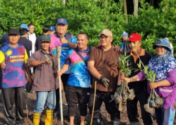 JEFRIDIN Atan ( tiga dari kanan  ) bersama  Zainal Eran ( kanan ) menanam pokok bakau pada program penanaman pokok Johor Peringkat Daerah Pontian di Jambatan Sungai Pulai, di Pontian, di sini.
