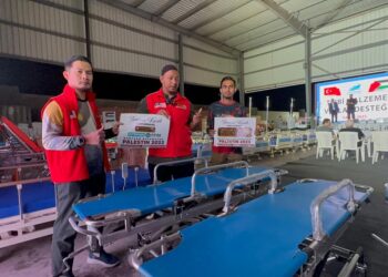 AHMAD Safuan (kiri) dan Mohd Johari (tengah) bersama sebahagian barangan perubatan yang disumbangkan MCM untuk dihantar ke Gaza.