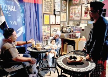 AHMAD Tarmedi (kanan) melayan pelanggannya di Pondok Rindu Kampung Lounge Cafe Bar di Felda Simpang Waha, Kota Tinggi.