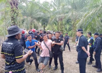 KEADAAN kekecohan semasa operasi pengusiran pekebun sayur di Kanthan, Ipoh hari ini. - UTUSAN