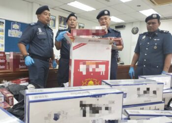 WAN Jamal Abdul Salam Wan Long (dua kanan) memeriksa rokok yang dirampas semasa sidang media di Pengkalan Kubor, Tumpat, Kelantan hari ini-UTUSAN/ROHANA ISMAIL.