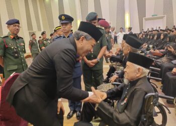 MOHAMAD Hasan menyempurnakan pemakaian PJM kepada salah seorang daripada penerimanya pada Majlis Penganugerahan PJM di Port Dickson hari ini.-UTUSAN/NOR AINNA HAMZAH.