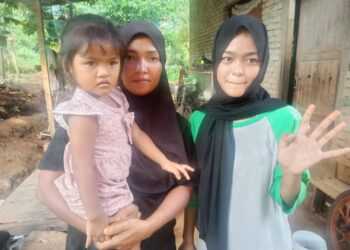 NURUL SYAFINAZ Mohd. Nazrul (kanan) disaksikan Nurul Wahida Kamarudin (kiri) menunjukkan jari telunjuk tangan kiri yang bengkak akibat sakit saraf di Felda Kota Gelanggi Dua di Jerantut, Pahang.