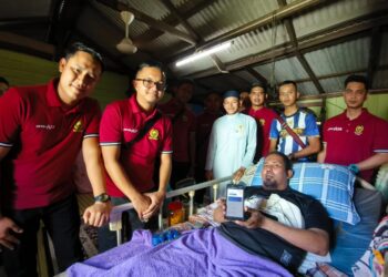 MOHD. Rahiman Aladin (kanan) menunjukan telefon yang digunakan untuk menjana pendapatan sebagai ejen dalam meneruskan kelangsungan hidup di Kampung Laut, Tumpat, Kelantan hari ini-UTUSAN/YATIMIN ABDULLAH