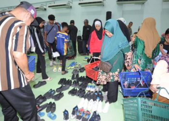 PENDUDUK kampung memilih kasut  sempena Free Market di MMHE, Pasir Gudang disini. UTUSAN/RAJA JAAFAR ALI