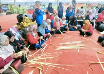 PARA peserta pertandingan menganyam ketupat sempena Festival D’ Kukup di Taman  Rekreasi Pantai Rambah, Pontian.