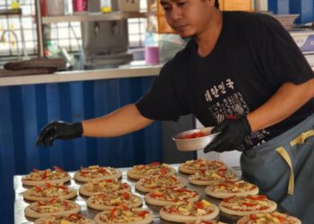 MUHAMMAD RIDHWAN AHMAD SAH menyediakan piza kayu api di kedai miliknya, Karkun Pizza di Bandar Putra IOI, Segamat.