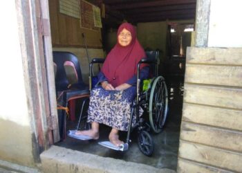 BADARIAH Ali Abdullah yang menggunakan kerusi roda menjadi mangsa banjir ketika ditemui di Kampung Baharu, Kampung Lalang, Baling.