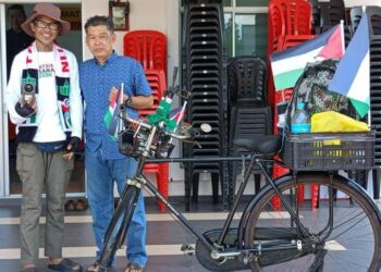 NAZRI Abdul Rahman mengambil peluang bergambar bersama Zul Yahya di Muar dalam jelajah berbasikal dari Ipoh ke Johor Bahru demi solidariti untuk rakyat Palestin di Muar, Johor, semalam.