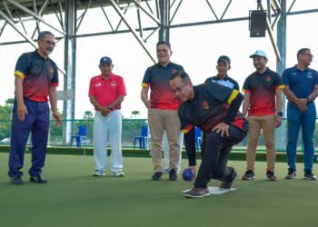 AHMAD Samsuri Mokhtar (kanan) ketika melakukan gimik balingan boling padang pada 
majlis penutup dan penyampaian hadiah Kejohanan Lawn Bowls Kebangsaan di Gong Badak, Kuala Nerus, semalam.