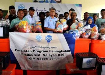 MUHAMMAD Faiz Fadzil menyampaikan peralatan menangkap ikan kepada salah seorang nelayan sempena  Majlis Ramah Mesra Madani Pengerusi LKIM Bersama Nelayan Negeri Johor di Kompleks Nelayan Kampung Pasir Gudang Baru, Johor. UTUSAN/RAJA JAAFAR ALI