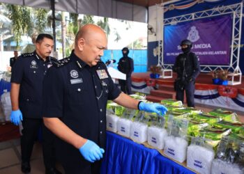 MOHD. kamarudin Md. Din (kiri) menunjukkan dadah yang dirampas semasa sidang media di Ibu Pejabat Polis Kontinjen Kelantan (IPK) Kota Bharu, Kelantan.-UTUSAN/KAMARUL BISMI KAMARUZMAN