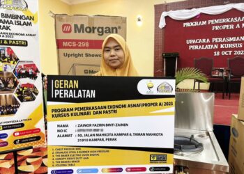 ZAINOR Fazrin Zainen menerima bantuan peralatan perniagaan daripada MAIPk pada majlis di Ipoh. - UTUSAN/LIYANA RAMLI