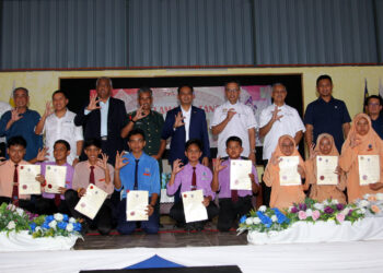 KHAIRUDIN Abu Hanipah (belakang, empat dari kiri) bersama penerima pada Majlis Penyerahan Laptop dan Program E-Kelas Melalui CSR Maxis Berhad di SMK Malim Nawar di Kampar hari ini. - UTUSAN