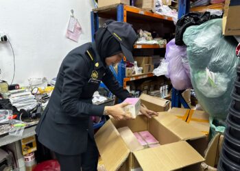 SEORANG anggota penguat kuasa KPDN Pulau Pinang memeriksa barangan berjenama terkenal yang disyaki tiruan dalam serbuan terhadap dua buah premis perniagaan di Bukit Mertajam, Pulau Pinang semalam.