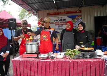 RUZAIDI Mamat (tiga, kanan) melihat masakan ikan patin di sebuah gerai pameran pada Program Rasa-Rasa Akuakultur Terengganu 2023 di Pasar Tani Hiliran, Kuala Terengganu, hari ini. - UTUSAN/PUQTRA HAIRRY ROSLI