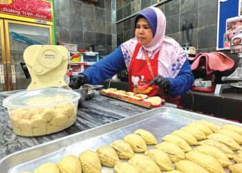 JAMALIAH Md. Yatim menyiapkan tempahan kuih sejuk beku yang diusahakannya di Ipoh, Perak. – UTUSAN/LIYANA RAMLI