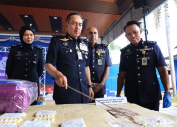 MUHAMAD Zaki Harun menunjukkan rantai emas yang dirampas bersama dadah di Ibu Pejabat Polis Kontinjen Kelantan, Kota Bharu, semalam. - UTUSAN/KAMARUL BISMI KAMARUZAMAN