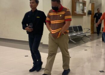 TERTUDUH, Rozairi Ismail (kanan) dibawa keluar dari kamar Mahkamah Sesyen Kuantan, selepas mengaku bersalah atas 15 pertuduhan menerima suapan. - UTUSAN/ DIANA SURYA ABD WAHAB