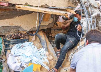 WARGA Palestin berusaha mengeluarkan mangsa di bawah runtuhan bangunan dekat kem pelarian Rafah, Gaza, semalam. - AFP