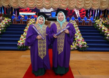 GRADUAN OKU, Wan Nursolehah (kiri) bersama pasangan kembar tak seirasnya, Wan Nurfatihah gembira dapat menamatkan pengajian pada Majlis Konvokesyen UMT Kali Ke-21 di Kuala Nerus, hari ini. - UTUSAN/KAMALIZA KAMARUDDIN