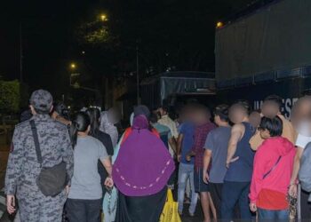 SEBAHAGIAN warga asing yang ditahan di kondominium mewah di Jalan Munshi Abdullah di ibu negara awal hari ini. - IHSAN IMIGRESEN