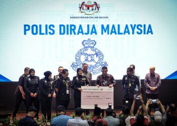 SAIFUDDIN Nasution Ismail ketika menyampaikan replika cek Pertandingan Pameran Projek Inovasi kepada PDRM di KDN, Putrajaya. - UTUSAN/FAIZ ALIF ZUBIR