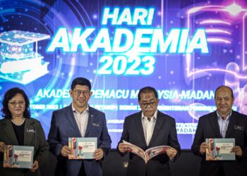 MOHAMED Khaled Nordin melihat buku Garis Panduan Perantisan pada Majlis Perasmian Hari Akademia dan Bulan Akademia Peringkat Kebangsaan Tahun 2023 di KPT, Putrajaya. - UTUSAN/FAIZ ALIF ZUBIR