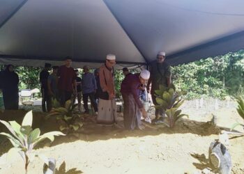 Md. Noor Hassan (kiri) memerhatikan anak keenamnya. Imaddudin menyiram air mawar di pusara isterinya, Taibah Sulaiman di Tanah Perkuburan Islam Teluk Wang, Sungai Petani.