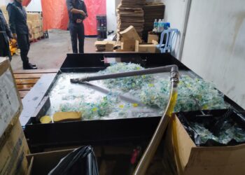 MINYAK masak paket 1kg dipotong dan dipindahkan ke dalam tangki serta dibotolkan semula sebelum dijual dalam serbuan di sebuah premis di Pelabuhan Klang. - GAMBAR IHSAN KPDN