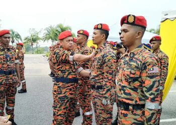 NORDIN Pauzi (tengah) melekatkan patch PPDA kepada pegawai yang menamatkan kursus di Akademi Bomba dan Penyelamat Malaysia Wilayah Utara di Tronoh hari ini. - UTUSAN