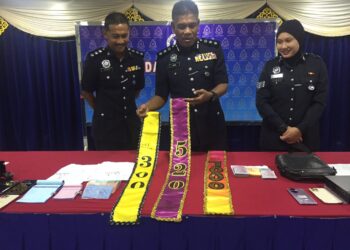 WAN MOHD. ZAHARI Wan Busu (tengah) menunjukkan kain selempang mempamerkan harga bagi mendapatkan layanan wanita warga asing yang bekerja di pusat hiburan dalam sidang akhbar di Ibu pejabat Polis Daerah di Kuantan, Pahang. - UTUSAN/DIANA SURYA ABD WAHAB