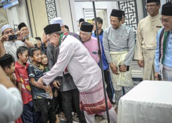 ANWAR Ibrahim menyantuni jemaah selepas menunaikan solat Jumaat bersama rakyat di Masjid Mahmoodiah, Presint 18, Putrajaya. - UTUSAN/FAIZ ALIF ZUBIR
