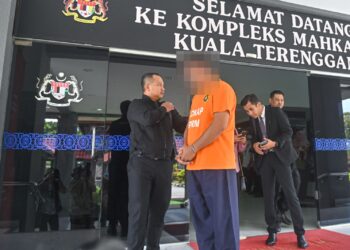 ANGGOTA polis berpangkat konstabel yang disyaki meminta dan menerima rasuah dibawa keluar dari Mahkamah Majistret Kuala Terengganu, hari ini. - UTUSAN/TENGKU DANISH BAHRI TENGKU YUSOFF