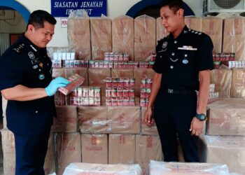 MAZLI Mazlan (kiri) memeriksa rokok seludup  yang dirampas di Kampung Pachakan, Kuala Besut, Besut, hari ini.