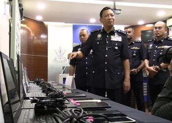 YAHAYA Othman (tengah) menunjukkan barang rampasan antaranya laptop dan telefon bimbit dalam serbuan sindikit pelaburan tidak wujud selepas sidang media di Ibu pejabat Polis Kontinjen Pahang, dekat sini, hari ini. UTUSAN/ DIANA SURYA ABD WAHAB