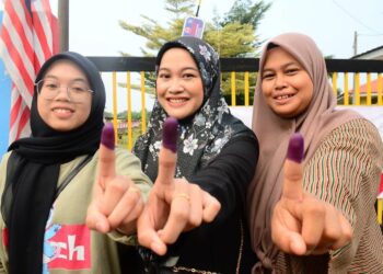 FARINI NADIRA (dari kanan), Farini Nabila dan Farini Ellisa Najwa berbangga menunjukkan jari mereka yang dicelup dakwat selepas mengundi pada PRK DUN Pelangai di SMK (LKTP) Felda Chemomoi.