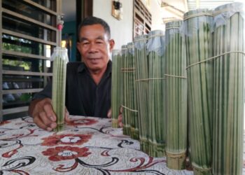 ZAKARIA Ideris menunjukkan sebahagian daripada susu masam yang diisi dalam buluh di rumahnya Kampung Cheting, Hulu Terengganu, Terengganu. - UTUSAN/NOOR HAYATI MAMAT