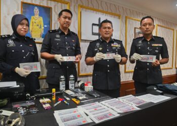 MAZLI Mazlan (dua, kanan) menunjukkan wang palsu RM100 yang dirampas di IPK Terengganu, Kuala Terengganu, hari ini. - UTUSAN/PUQTRA HAIRRY ROSLI