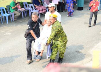 MOHD. SHAARI Mat Dom diusung menggunakan kerusi di pusat mengundi SMK (LKTP) Felda Chemomoi pada PRK DUN Pelangai. - FOTO/SHAIKH AHMAD RAZIF