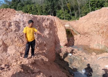 SEORANG penduduk menunjukkan lokasi ketiga-tiga mangsa tertimbus runtuhan tanah di tapak projek pembinaan lebuh raya di Kampung Maka, Pulai Chondong, Machang, Kelantan hari ini-UTUSAN/ROHANA MOHD. NAWI