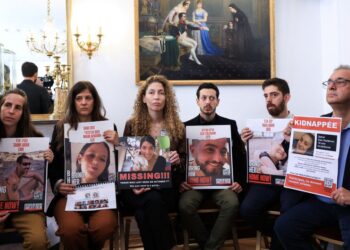 WARIS tebusan yang ditahan Hamas memegang gambar ahli keluarga mereka semasa pertemuan di Perhimpunan Kebangsaan Perancis di Paris.-AFP