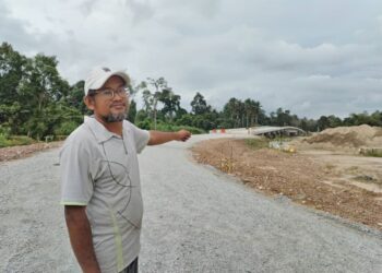 MOHD. Arif Deraman menunjukkan jambatan sepanjang 200 meter yang masih dalam pembinaan di Kampung Seri Bayas, Setiu, Terengganu, semalam. - UTUSAN/WAN ZURATIKAH IFFAH WAN ZULKIFLI