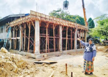 SITI Mariam Jusoh menunjukkan stor yang masih dalam pembinaan sebagai persiapan menghadapi musim tengkujuh di Kampung Siram, Pasir Mas, Kelantan. - UTUSAN/ROHANA ISMAIL